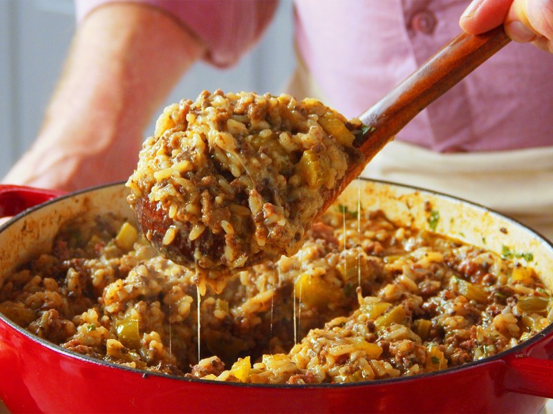 Una sartén de arroz sucio estilo cajún, de la que se saca una porción con una cuchara.