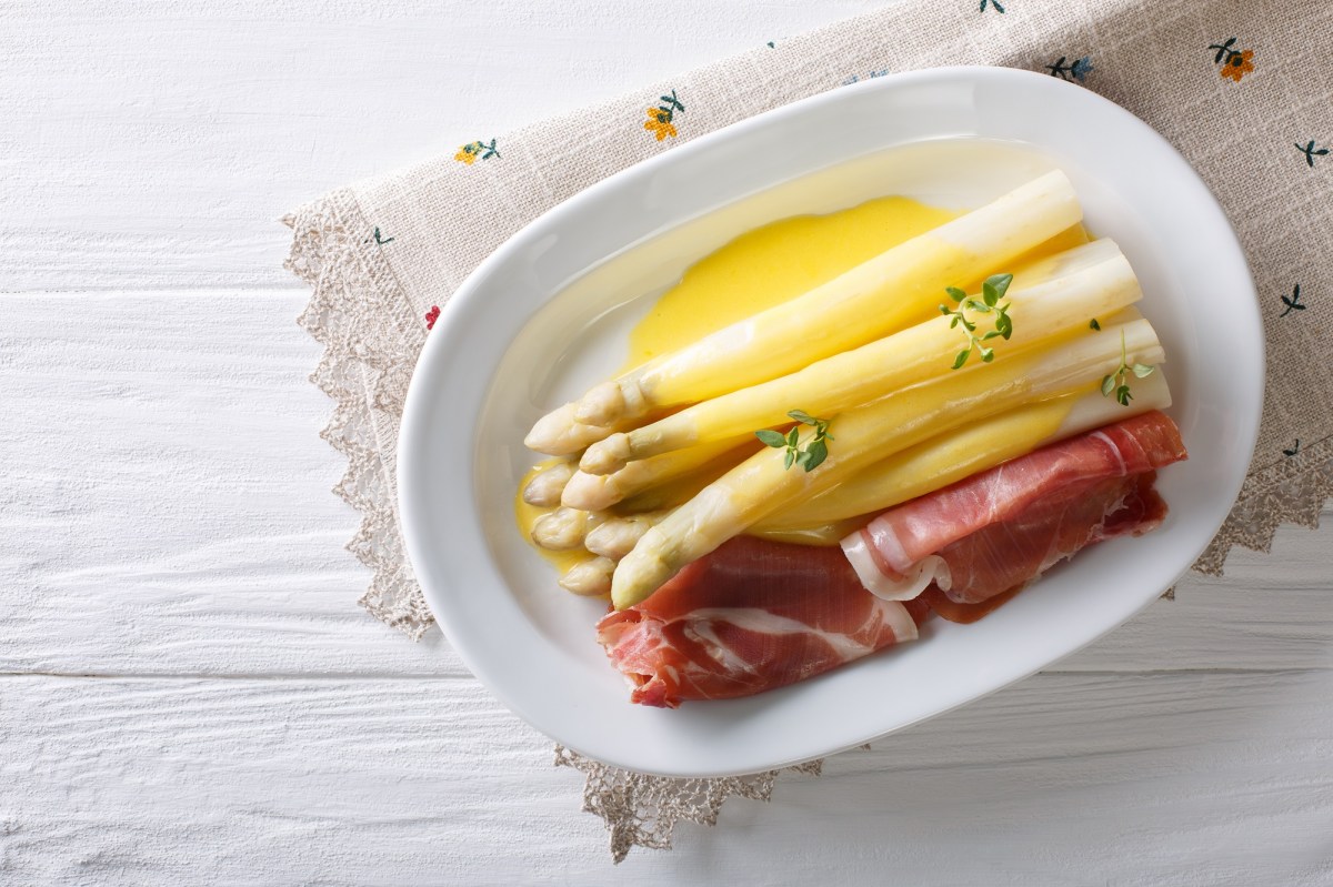 Plato con espárragos blancos, jamón y salsa de azafrán