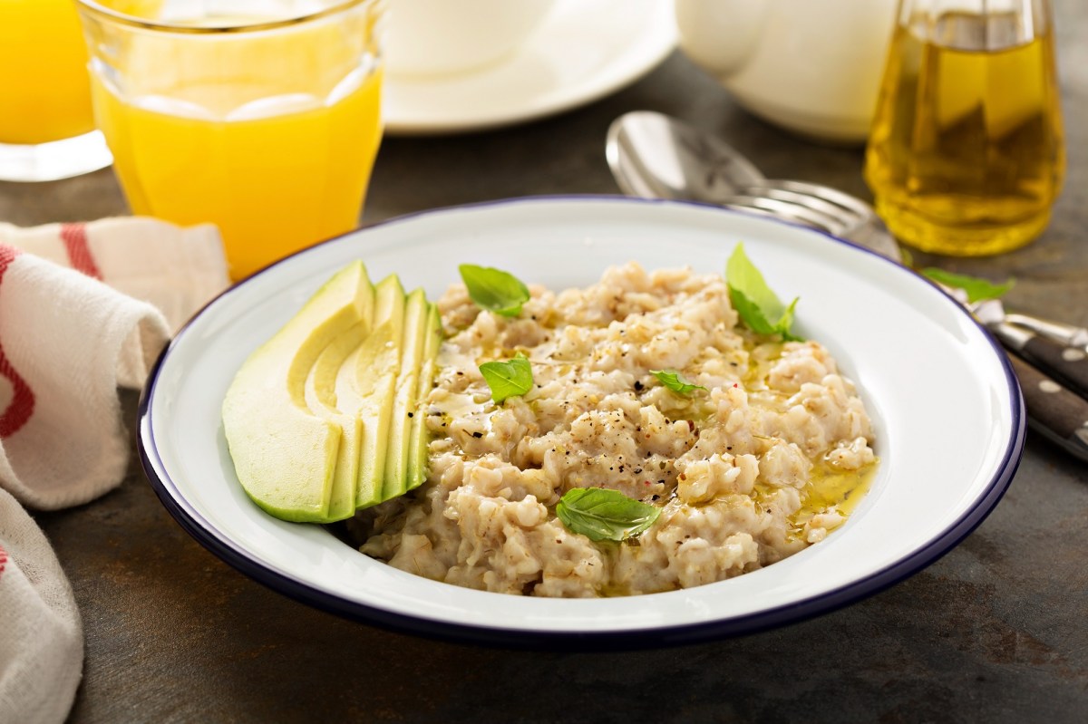 Gachas de avena con aguacate y aceite de oliva en un plato, acompañado de diversas bebidas.