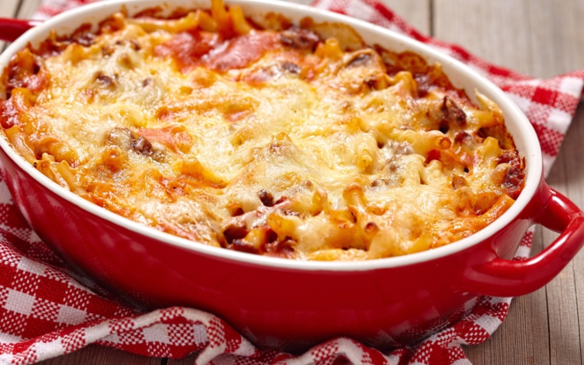 Macarrones al horno a la mamma en una fuente roja para horno.