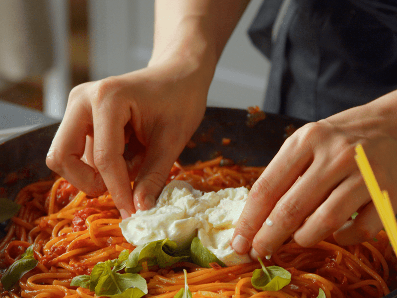 Sartén con espaguetis en una olla con burrata