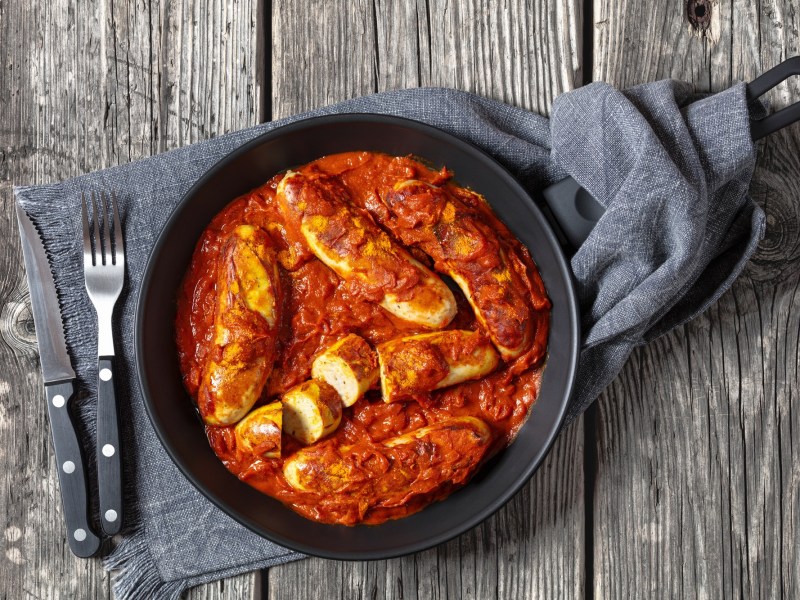 Sartén de currywurst con cubiertos al lado