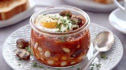 Un desayuno inglés en frasco en un plato. Junto a él hay una cuchara.