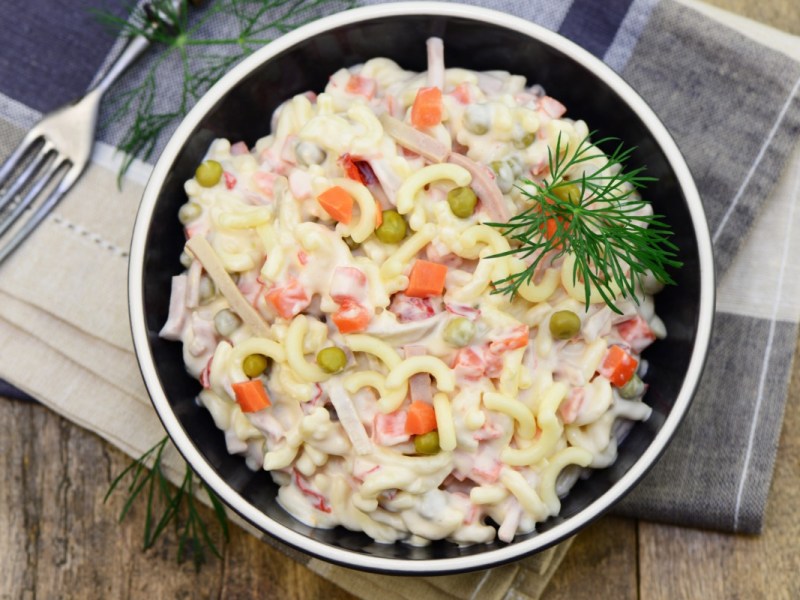 Un tazón con ensalada de pasta con mayonesa en vista superior.