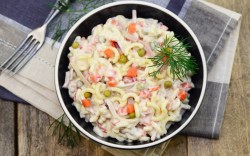 Un tazón con ensalada de pasta con mayonesa en vista superior.