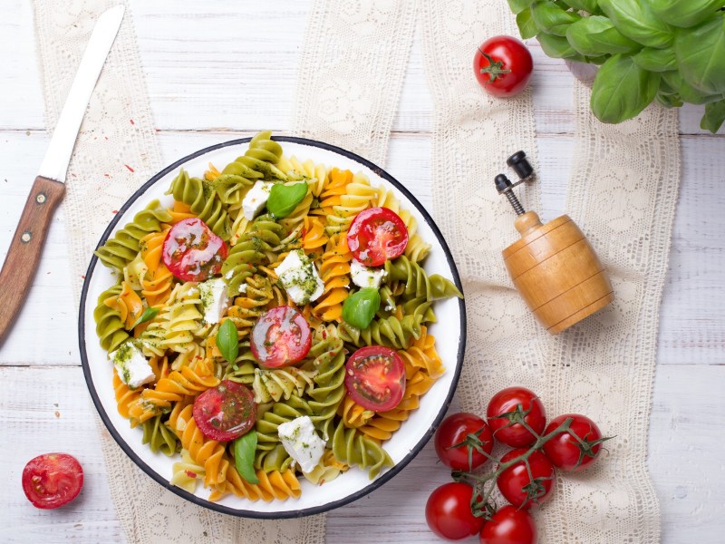Tazón con ensalada de pasta mediterránea con pesto.