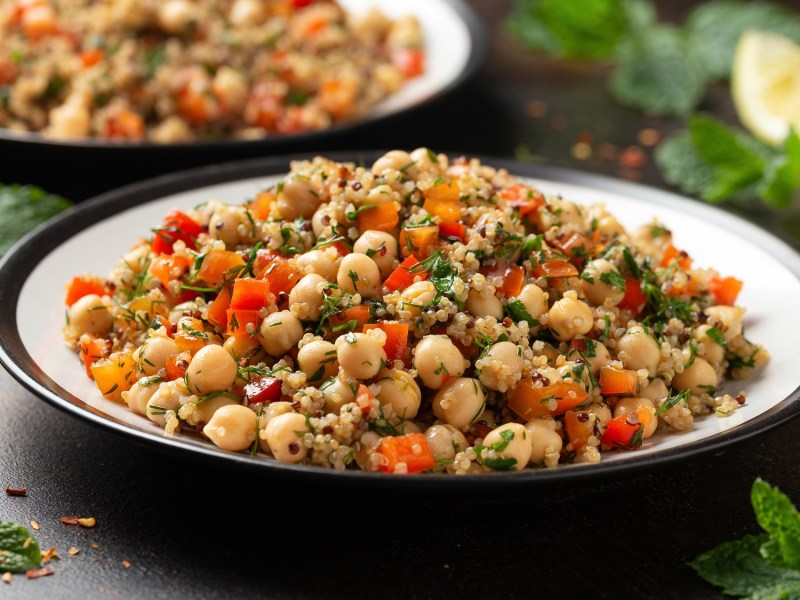 Un tazón de ensalada tailandesa de quinoa con garbanzos y verduras.