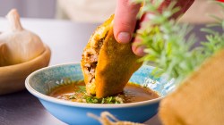 Taco de birria que se sumerge en salsa