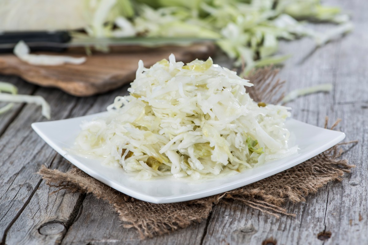 Ensalada de col en un plato cuadrado sobre una servilleta de tela gris.