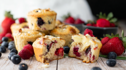 Varios muffins de bayas y brie, en primer plano hay uno partido por la mitad.