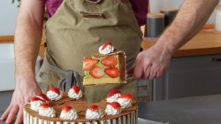 Se ve como un cocinero saca una porción de pastel de bizcochos de chocolate. En el fondo se ve un juego de cocina.