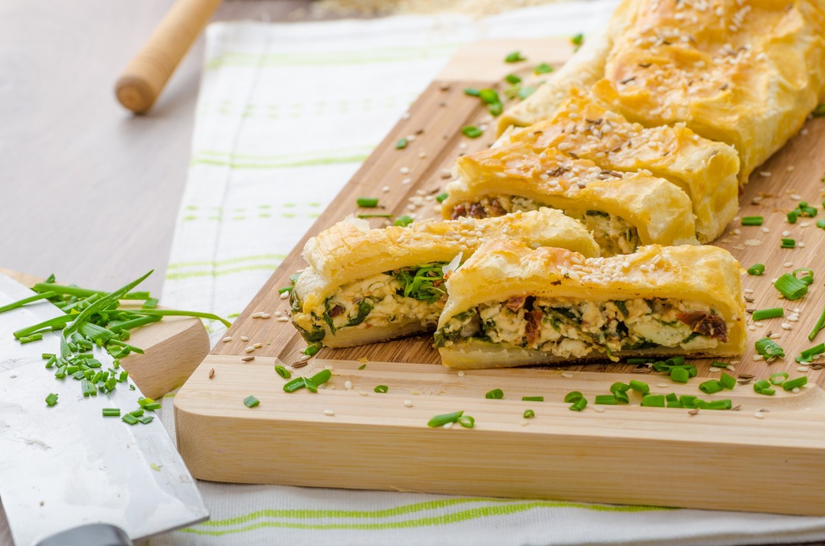 Tabla con strudel de hojaldre con espinacas y queso azul cortado